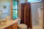 The master bathroom gets a lot of natural light with its large window high enough for privacy a top a mountain 